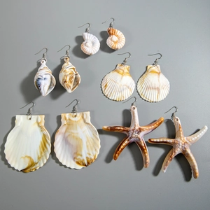 Detail showing five pairs of ocean-themed earrings with shells and starfish charms