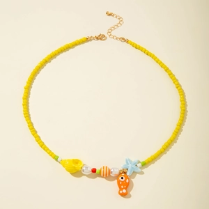 Detail of yellow beaded necklace with starfish, seashell and fish charms for beachwear