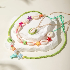 Detail of colorful beaded necklaces with starfish and shell charms on stone pedestals