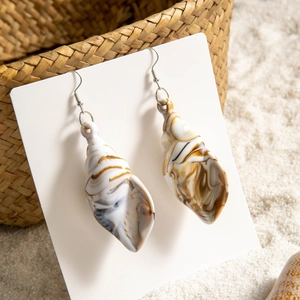 Detail of beach style shell earrings with brown marble texture and silver hooks