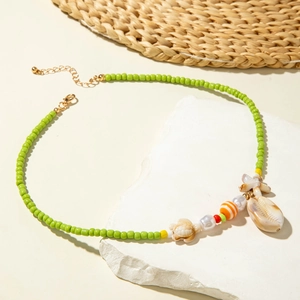 Detail of beaded beach necklace with starfish, seashell, and turtle charms on a textured base
