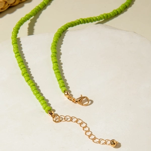 Detail of lime green beaded necklace with gold lobster clasp and adjustable extension chain