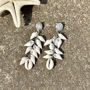 Detailed view of beach-style shell tassel earrings with white conch and starfish studs