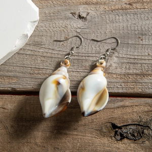 Macro shot of natural shell drop earrings with polished silver metal hooks