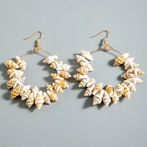 Detail view of large hoop earrings made of natural cone shells with golden hooks