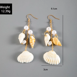 Detail of seashell pearl tassel earrings with golden hooks and beach starfish motifs