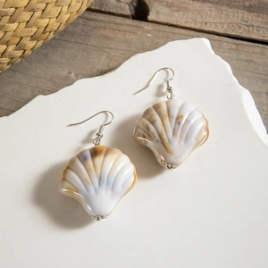 Detailed macro view of shell drop earrings with elegant silver flower metal base
