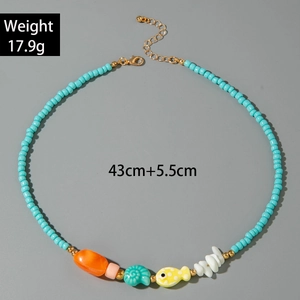 Detail of blue beaded necklace featuring sea shells, fish charms and colorful beads