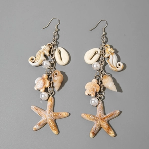 Macro detail of beach-themed earrings featuring seahorse, turtle, and starfish charms