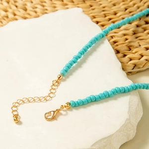 Detail of turquoise seed bead necklace with gold lobster clasp and adjustable chain