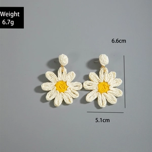 Detail view of handmade woven daisy raffia earrings showing weight 6.7g and 6.6cm size