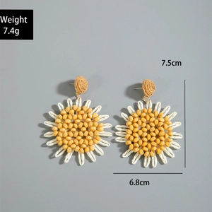 Detail shot of handmade sunflower raffia earrings showing 7.5cm size and 7.4g weight