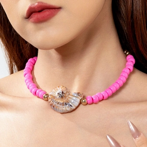 Close-up of pink beaded starfish seashell necklace worn on woman neck for beach vacation