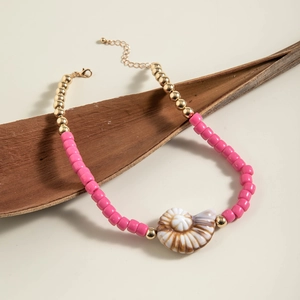 Macro view of bohemian beaded necklace featuring pink beads and a natural seashell pendant
