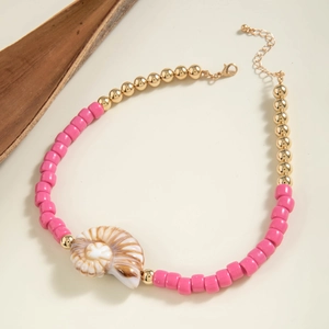 Detail of pink and gold beaded necklace featuring a striped nautilus shell pendant