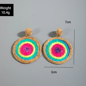 Detail shot of leaf-shaped rainbow woven raffia earrings showing 7cm length and 10.4g weight