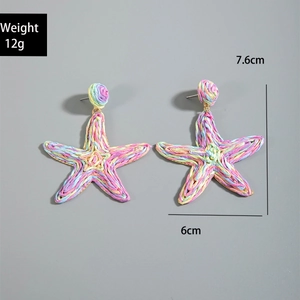 Detailed view of handmade colorful raffia earrings in starfish shape with size markers