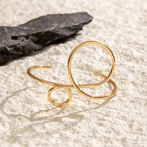 Detailed view of minimalist gold geometric hollow bracelet on natural stone surface