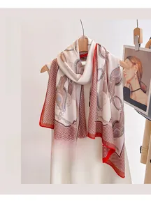 Detail of equestrian print silk scarf with bridle patterns and red contrast border