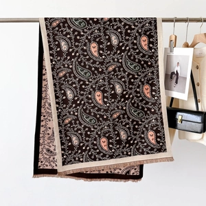 Detail of premium brown paisley scarf with elegant tassels and soft drape texture