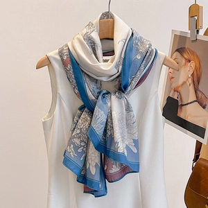 Floral print silk scarf featuring birds and botanical patterns on light blue and pink fabric