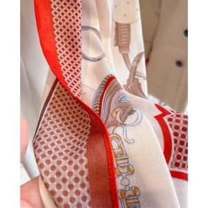 Elegant silk scarf with red edges and equestrian bridle pattern in a draped view