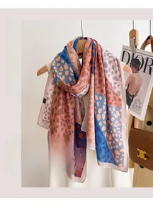 Close-up of summer silk scarf with abstract patterns on a wooden hanger with fashion props