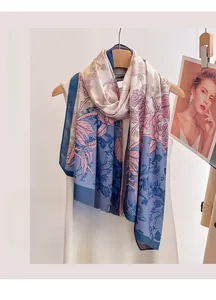 Detail of elegant floral cotton linen scarf with blue leaves and pink flowers on a hanger