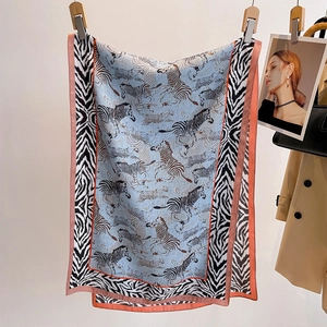 Eleganter Seidenschal mit Zebra- und Leopardenmuster auf hellblauem Hintergrund