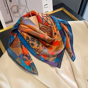 Artistic geometric print silk scarf with multicolor blocks styled on a beige blazer