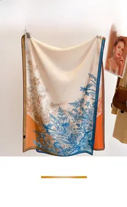 Detail view of lightweight floral silk scarf with elegant blue botanical prints and orange accents