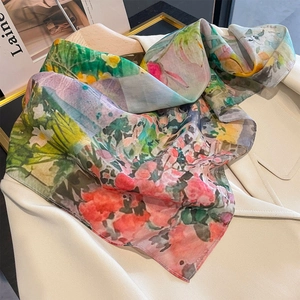 Floral oil painting silk square scarf styled on a blazer for a chic spring look