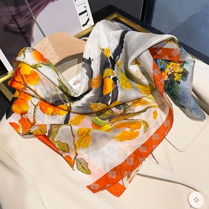 Foulard en soie rétro avec motifs de kakis orange et bordures rouges sur un blazer beige