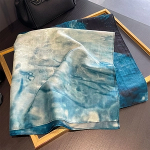 Artistic blue gradient silk scarf with abstract plant print displayed on a gold frame