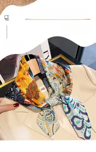 Detail of silk-like square scarf with paisley patterns styled as a suit accessory