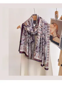 Detail of lightweight purple paisley silk scarf draped over a dress on a wooden hanger