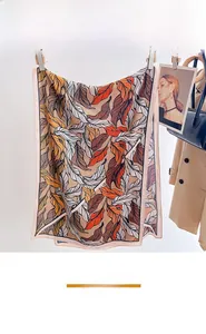 Detail of botanical leaf print scarf hanging with elegant pink hem and soft texture