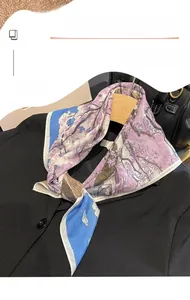 Close-up of printed silk square scarf with floral pattern styled on a black suit blazer