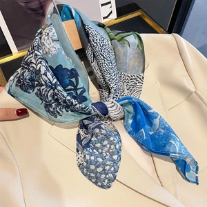 Carré en soie et coton bleu avec imprimé floral porté sur un blazer beige pour femme