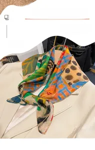 Dettaglio di un foulard di seta a fiori abbinato a un blazer beige e ad accessori