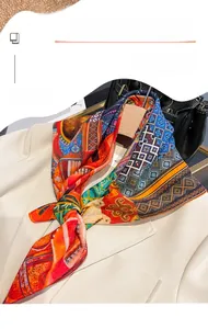 Close-up of printed silk-like square scarf with ethnic geometric patterns on a beige blazer