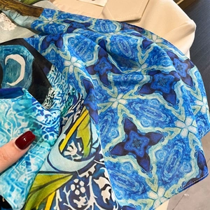 Détail de l'écharpe douce en mélange soie-coton avec des motifs floraux bleus abstraits