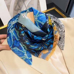 Vue détaillée d'un foulard en soie aux motifs abstraits bleus sur un cintre en bois