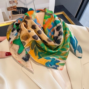 Sciarpa di seta con stampe floreali e leopardate su un blazer beige elegante