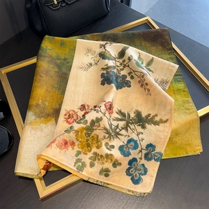 Elegant vintage landscape floral print silk scarf displayed on a golden frame