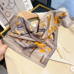 Modisches Seidentuch mit abstraktem Druck in Grau und Gelb auf einem Blazer