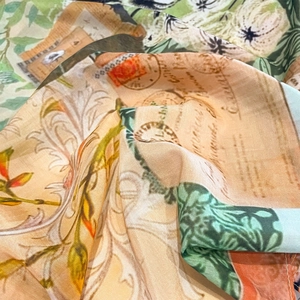 Close-up of silk scarf showing vintage floral prints, postal stamps and elegant texture