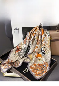 Detail of printed silk square scarf with animal motifs draped on a luxury leather handbag