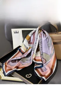 Close-up of printed silk square scarf with chain patterns draped over a luxury handbag