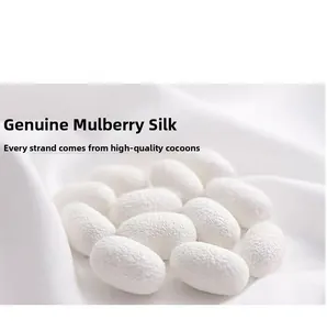 Detailed macro shot of 100% natural white mulberry silk cocoons on soft silk fabric